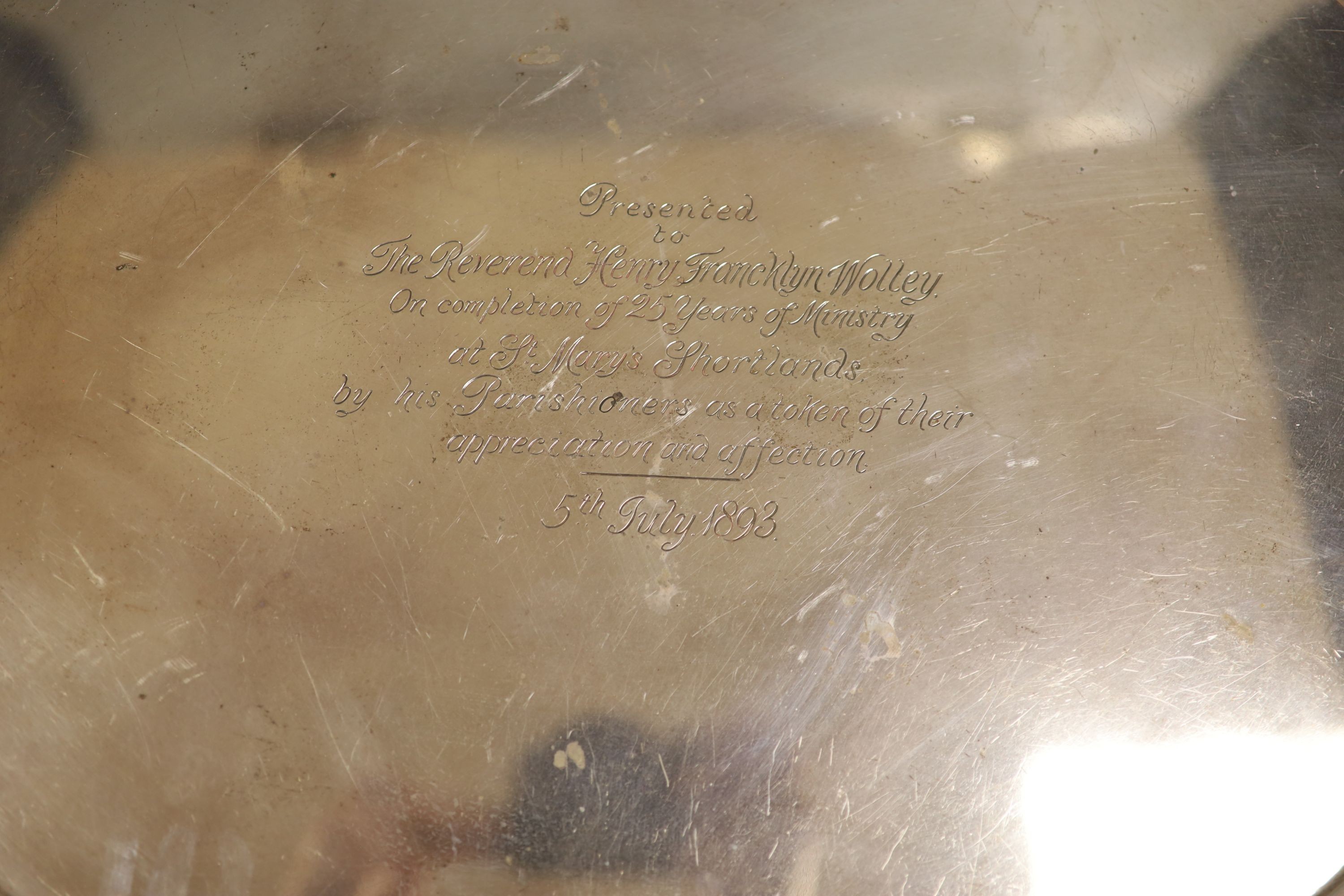 A late Victorian silver oval two handled tea tray, with gadrooned border and engraved inscription, George Gilliam, London, 1893, 62.8cm over handles, 99oz.